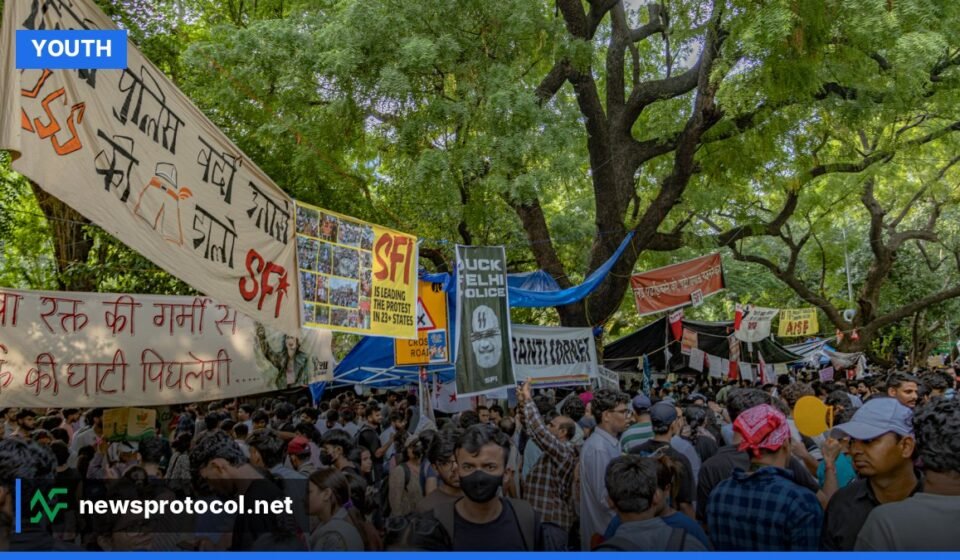 Young Indian demonstrators holding satirical signs during a 2026 protest in New Delhi