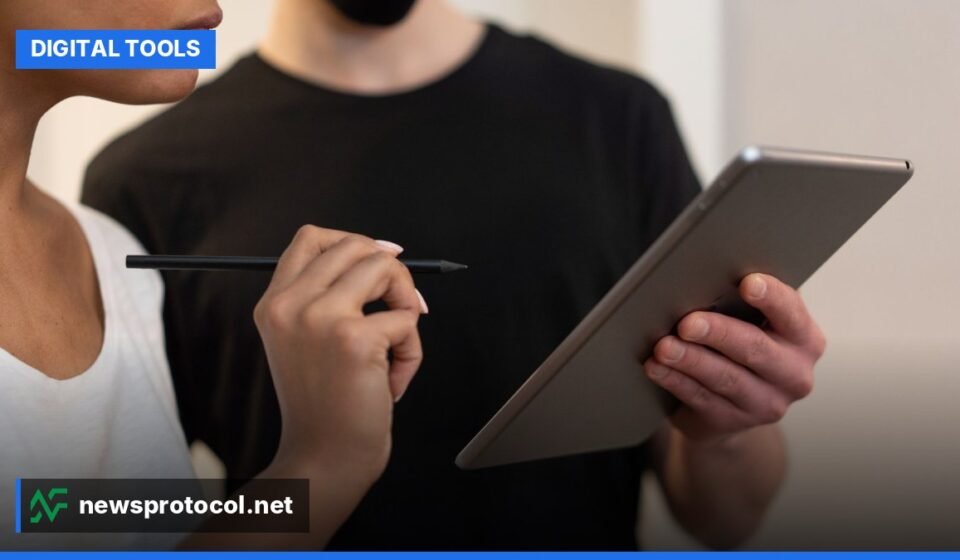 A diverse team collaborates on a digital project, using various online tools on laptops and tablets in a modern office.