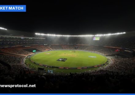 A brightly lit cricket stadium at night during a Twenty20 match with a packed audience.