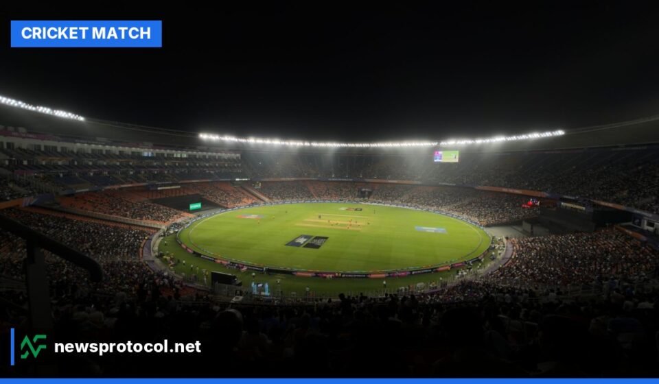 A brightly lit cricket stadium at night during a Twenty20 match with a packed audience.