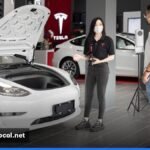 A freshly polished Tesla Model 3 displayed in a modern showroom.