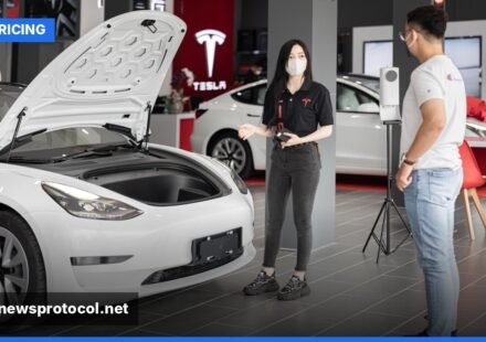 A freshly polished Tesla Model 3 displayed in a modern showroom.