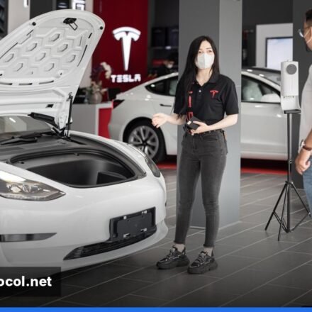 A freshly polished Tesla Model 3 displayed in a modern showroom.