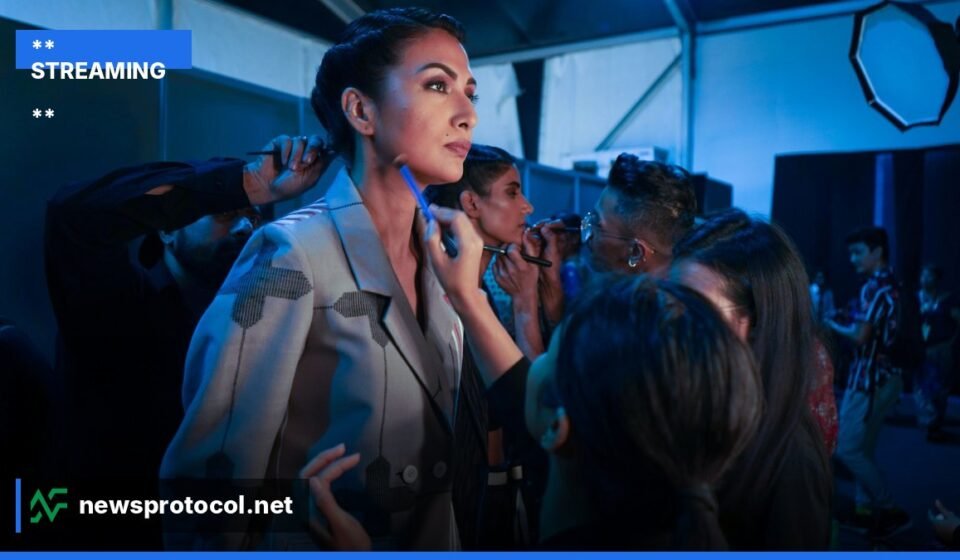 ** Backstage view of a fashion runway with models and lighting rigs. **