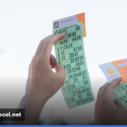 ** A close‑up of Lotto Max tickets and a glowing jackpot display at night. **